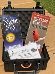 Binocular case contents including instruction manual, night sky guide, and backyard birds guide