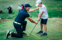 Adult demonstrating golf to a child