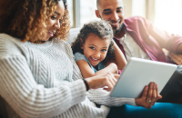 Parents and child looking at a tablet together